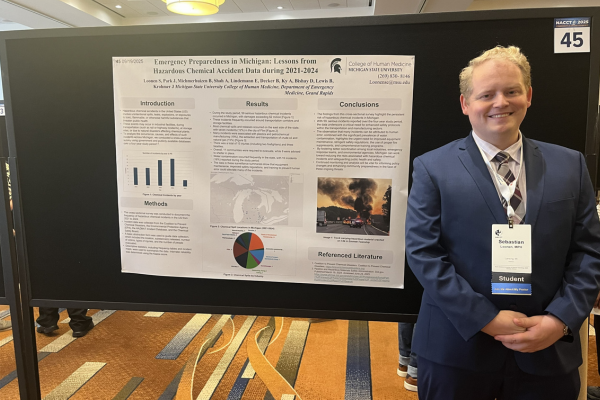 Sebestian Loonen standing in front of his poster presentation.
